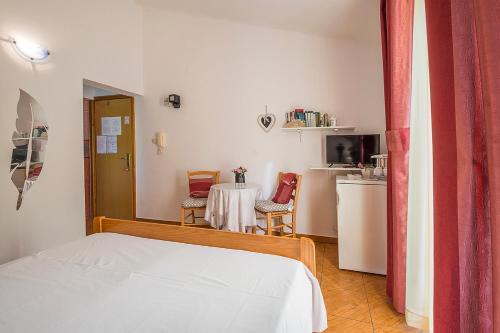 a room with a bed and a table and a kitchen at Apartman, studio and room Kata in Pula