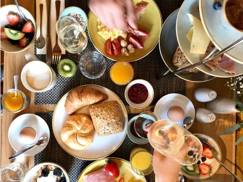 a table filled with plates of food and drinks at Hotel Tuchhaus in Volkach