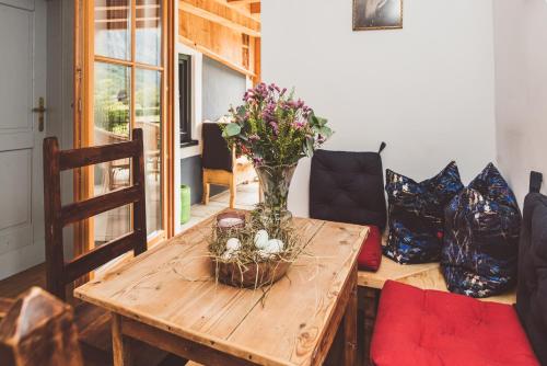 a wooden table with a vase of flowers on it at Chalet am Sonnenhang in Obertraun