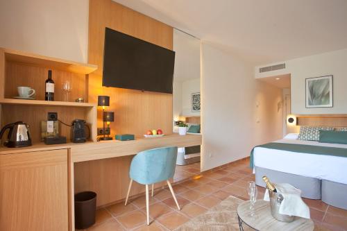 a bedroom with a bed and a desk with a chair at Mon Port Hotel & Spa in Port d’Andratx