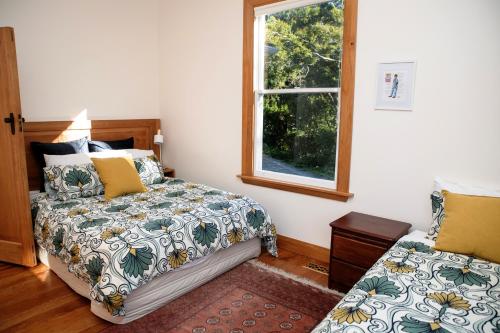 a bedroom with a bed and a window at Elegant Villa Nestled In The Trees in Nelson