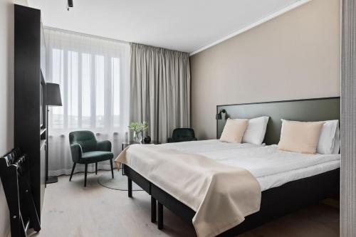 Un pat sau paturi într-o cameră la First Hotel Strand