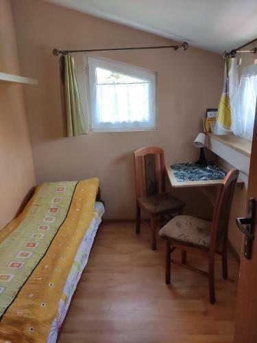 a bedroom with a bed and a desk and a window at Apartament przy plaży in Kuźnica
