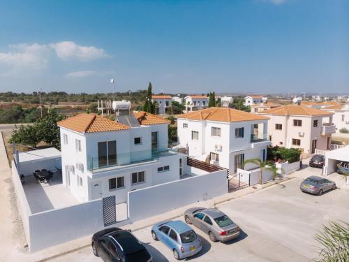 an aerial view of a house with cars parked in a parking lot at Agia Thekla Villa Ekaterina 4 bdrm in Ayia Napa
