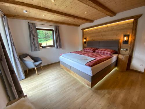 a bedroom with a bed and a chair in it at Ferienhaus Berggfui in Berchtesgaden