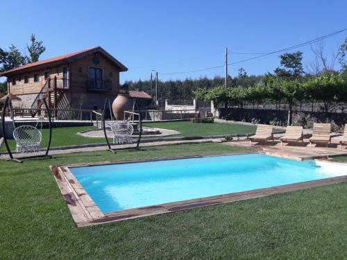 una piscina in un cortile con sedie e un parco giochi di Quinta Ze do Coval a Arouca