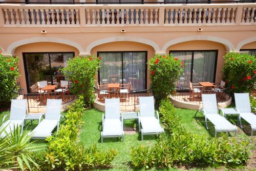 a patio at a hotel with white chairs and tables at Mon Port Hotel & Spa in Port d’Andratx