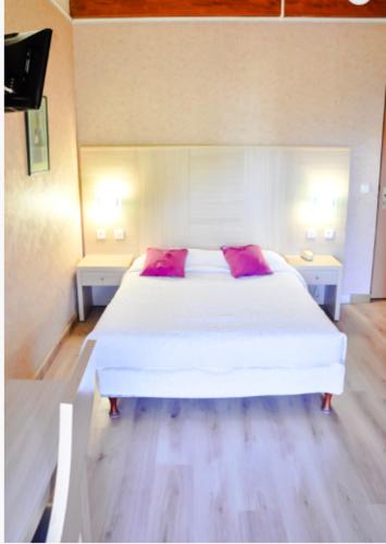 a bedroom with a white bed and two night stands at Résidence Stella Marina in Serriera