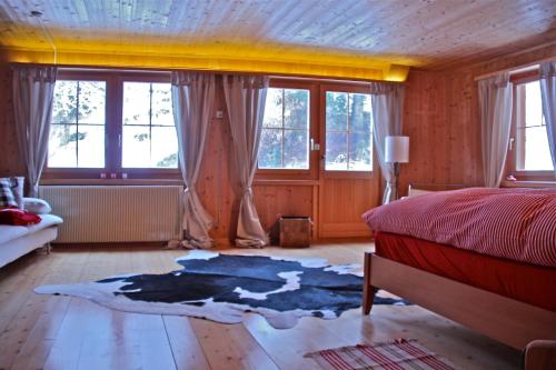 a bedroom with a bed and a rug on the floor at Tgesa Ferrera in Schmitten
