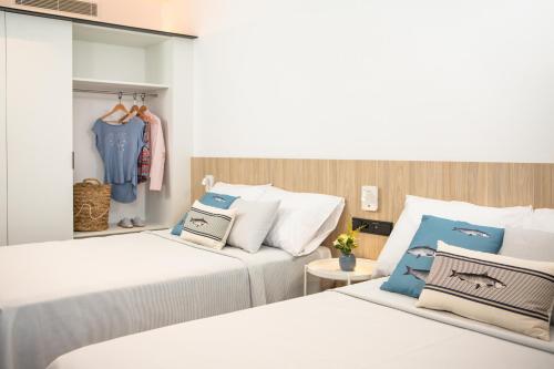 a bedroom with two beds and a closet at RVHotels Ametlla Mar in L'Ametlla de Mar