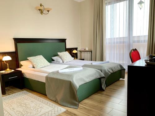a bedroom with two beds and a large window at Nocowanie Restauracja Wenecka in Kłobuck