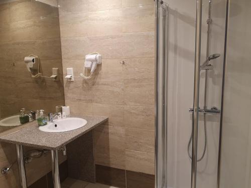 a bathroom with a sink and a shower at Hotel Relax in Słubice