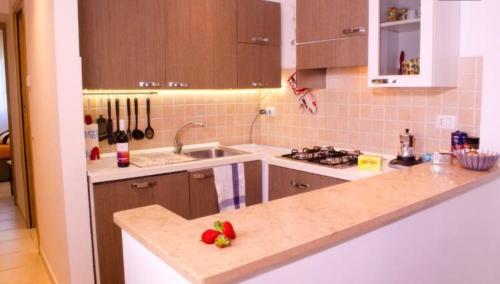 a kitchen with a sink and a counter with strawberries on it at Butterfly casa vacanze in Sutri