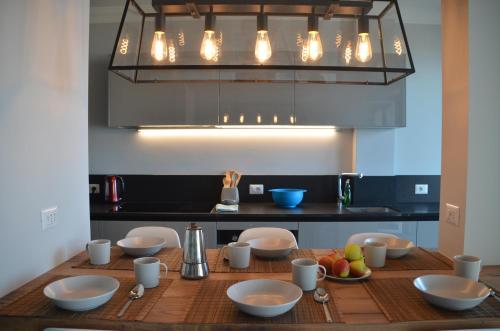 a kitchen with a wooden table with bowls and cups at Le Terrazze, Via Selvalunga 1, Stresa in Stresa