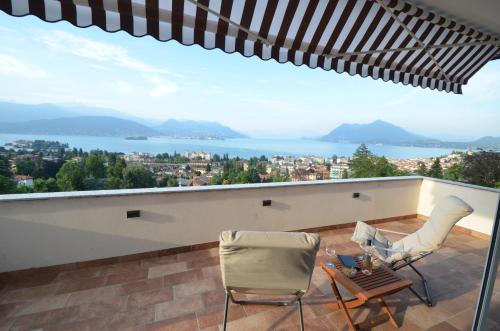 a balcony with chairs and a view of the water at Le Terrazze, Via Selvalunga 1, Stresa in Stresa