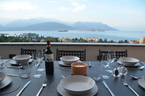 a table with a bottle of wine and a table with a view at Le Terrazze, Via Selvalunga 1, Stresa in Stresa
