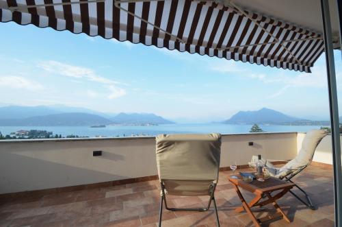 a patio with a table and chairs and a view of the ocean at Le Terrazze, Via Selvalunga 1, Stresa in Stresa