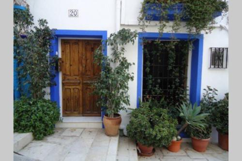 uma casa azul e branca com vasos de plantas na frente de uma porta em Casa de los Joses em Alicante