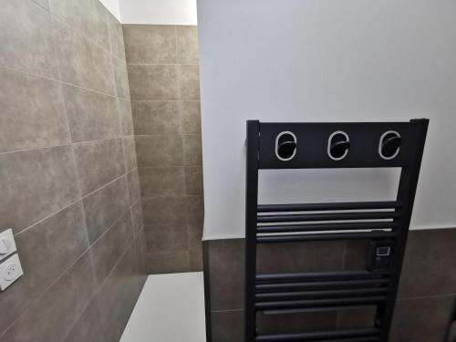a shower with a black chair in a bathroom at Gite du Panty in Saint-Tricat