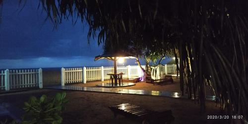 a table with an umbrella on the beach at night at Green Shadows Beach Hotel in Kalutara