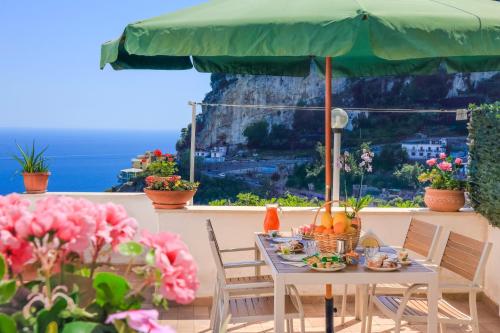 a table with food and a green umbrella at Villa Mare in Amalfi