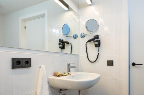 a white bathroom with a sink and a mirror at RVHotels Ametlla Mar in L'Ametlla de Mar
