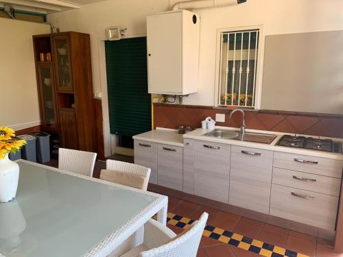 a kitchen with a sink and a table and chairs at Etna View Affittacamere in Giardini Naxos