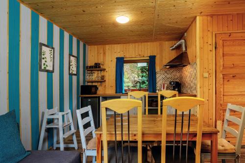 ヤストシェンビャ・グラにあるDomek obok Willi w Rozewiuのダイニングルーム(木製テーブル、椅子付)
