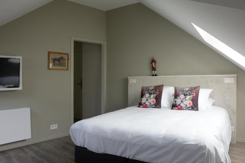 a bedroom with a white bed with two pillows at De Kaai in Halle