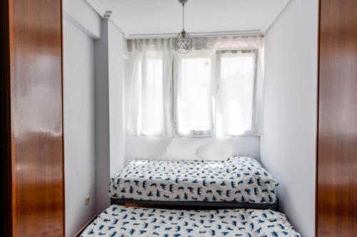 een bed in een kamer met een raam bij ¡Nuevo! Apartamento para 4 en playa de la Concha en Suances in Suances