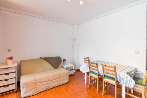een slaapkamer met een bed en een tafel en stoelen bij ¡Nuevo! Apartamento para 4 en playa de la Concha en Suances in Suances