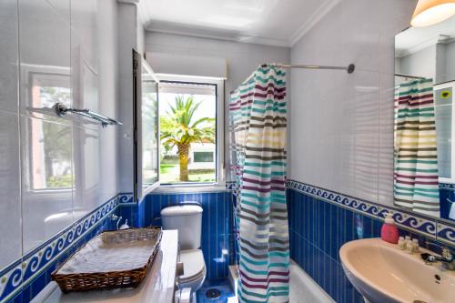 een badkamer met een wastafel, een toilet en een raam bij ¡Nuevo! Apartamento para 4 en playa de la Concha en Suances in Suances