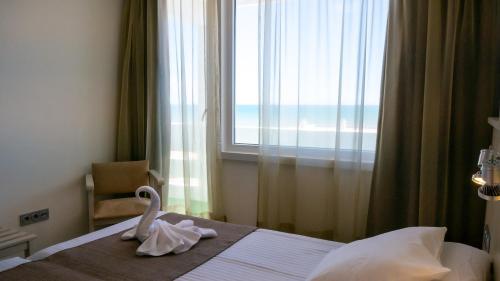un dormitorio con un cisne en una cama con ventana en Apartamentos Turisticos Flamero en Matalascañas