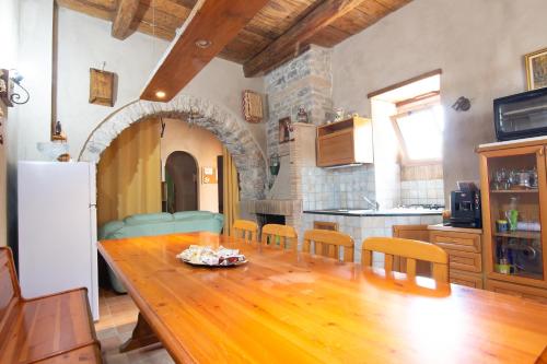 una cucina con tavolo in legno e una cucina con frigorifero di Case Vacanze La Venere a Rocca Imperiale