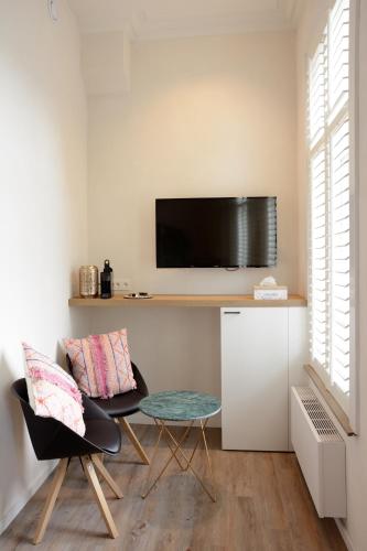 a living room with a table and a tv on a wall at De Kaai in Halle