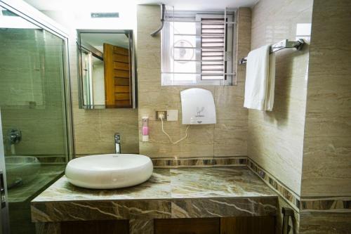 a bathroom with a sink and a shower at Shinepukur Suites in Dhaka