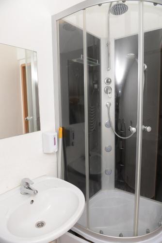 a bathroom with a shower and a white sink at Villa Basia in Rybnik
