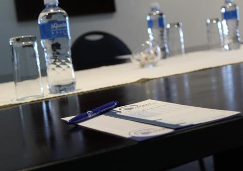 a table with a pen and a bottle of water at Blue Lagoon Hotel and Conference Centre in East London