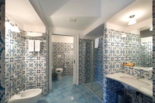 a bathroom with blue and white tiled walls and a toilet at Palazzo Marzoli charme Resort - Small Luxury Hotel in Positano