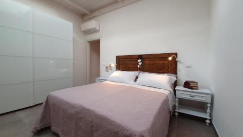 1 dormitorio con 1 cama grande y cabecero de madera en RomagnaBNB Dal Mazareta, en Forlimpopoli