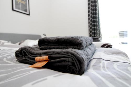 a pile of towels sitting on top of a bed at Modern Balcony Apartment with Pool close to Lake in "Donaustadt" in Vienna