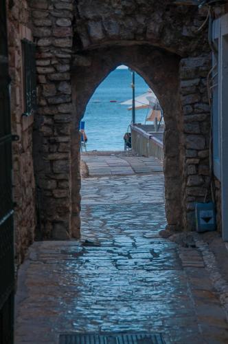 an archway in a stone building with a view of the ocean at Hotel Astoria in Budva