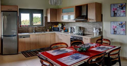 a kitchen with a table with a red table cloth at Villa Horizon in Skouloúfia