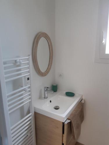 a white bathroom with a sink and a mirror at ETABLISSEMENT CHEZ JULES in Ambleteuse