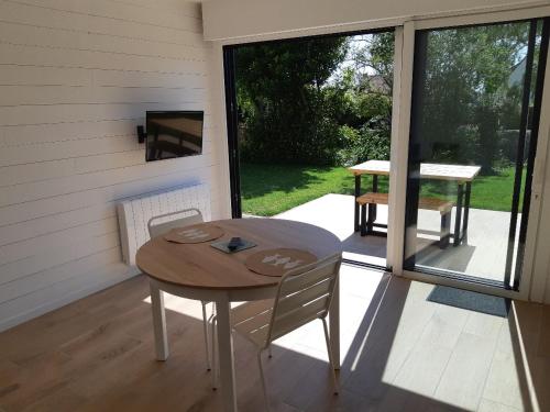 a table and chairs on a screened in porch at ETABLISSEMENT CHEZ JULES in Ambleteuse
