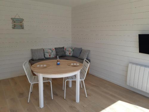 a room with a table and chairs and a couch at ETABLISSEMENT CHEZ JULES in Ambleteuse