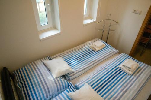 1 cama con 2 toallas en un dormitorio en Dollár Apartman en Orfű