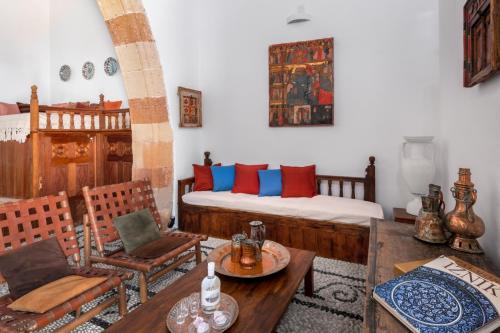 een woonkamer met een bed en een tafel en stoelen bij Antique Villa in Lindos