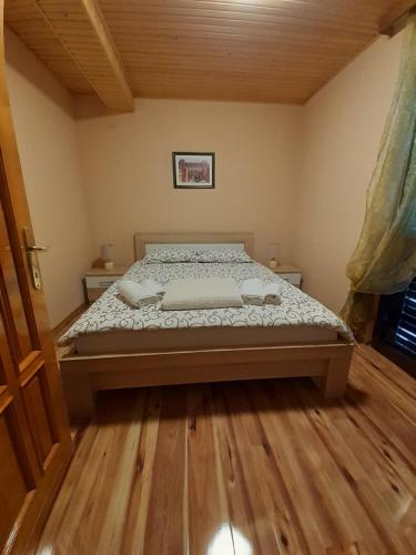un letto in una camera da letto con pavimento in legno di Apartman Damjanovic a Cetinje (Cettigne)