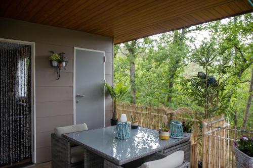 a screened in porch with a table and chairs at CHALET MAAIKE in Durbuy